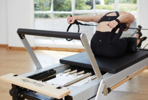 מתיחה קרוספיט על מכשיר Pilates כמו חדש מועדון כושר ותמרון גמישות.